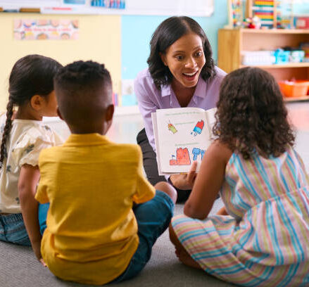Class Of Primary Or Elementary School Students Raising Hands To Answer Question In Classroom